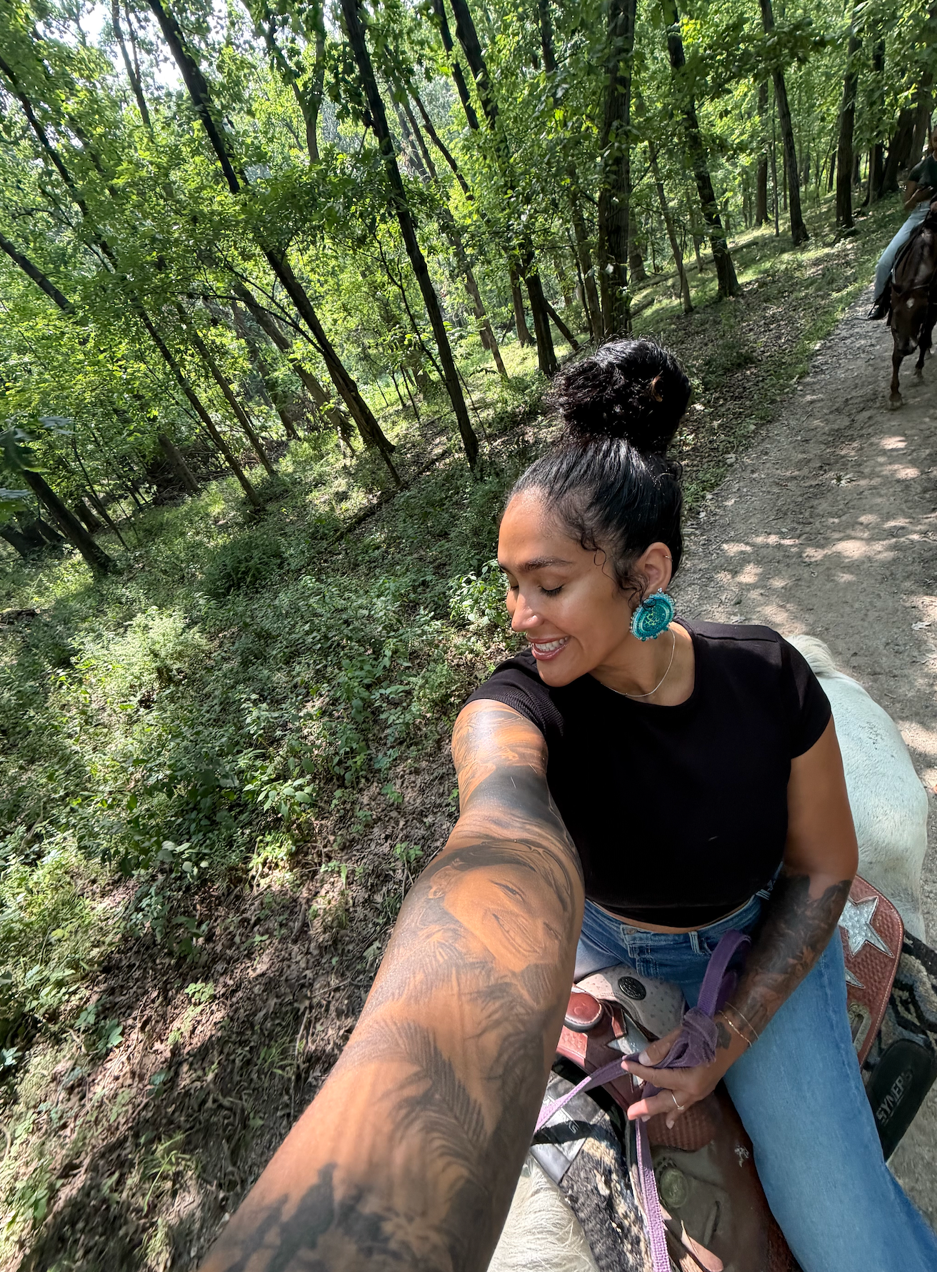 Woman riding through a wooded trail